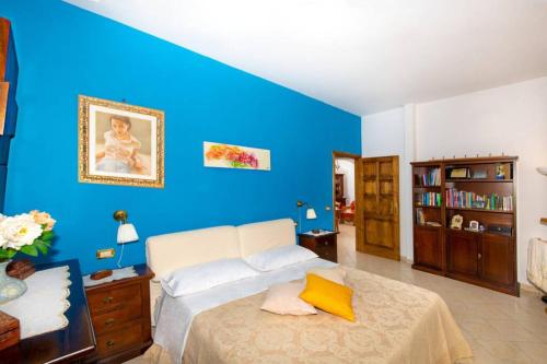Dormitorio azul con cama y pared azul en Villa Aurora Oasi Verde, en Sorrento