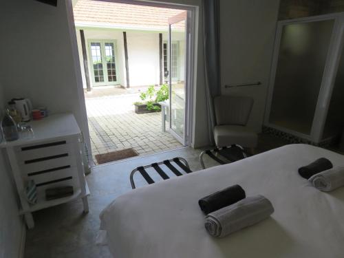 a bedroom with a bed with two rolled towels on it at Bare Feet Retreat in Scottburgh