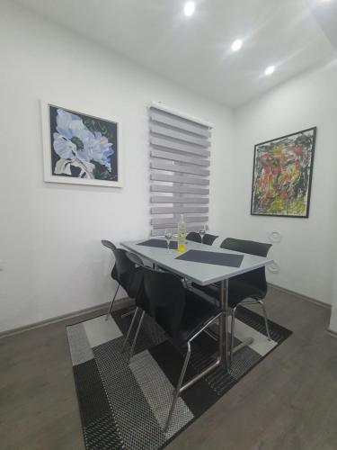ein Esszimmer mit einem Tisch und schwarzen Stühlen in der Unterkunft Apartman DIN in Travnik