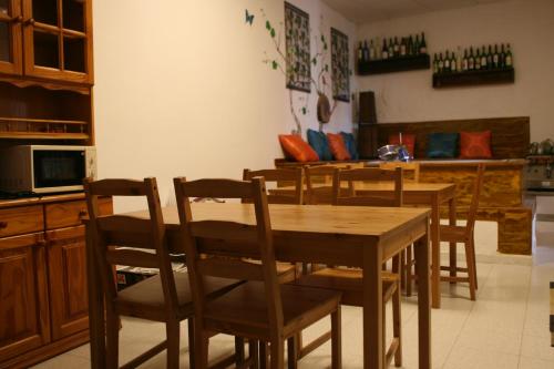 La Palma Hostel by Pension Central في فوينكالينتي دي لا بالما: مطبخ مع طاولة وكراسي خشبية