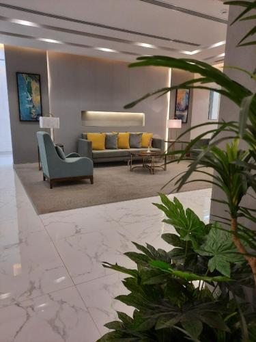 a living room with a couch and a chair at الأجنحة التنفيذية للشقق المخدومة - اقتصادي in Riyadh