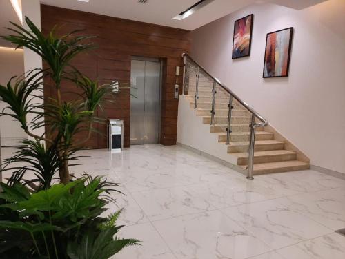 a hallway with stairs and plants in a building at الأجنحة التنفيذية للشقق المخدومة - اقتصادي in Riyadh