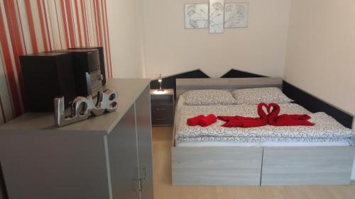 a bedroom with a bed with a red ribbon on it at Gere MODERN Apartment in Harkány
