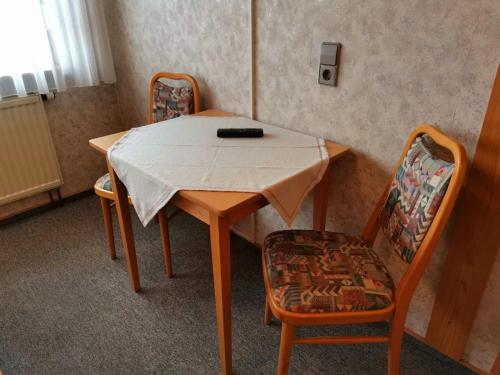 a table with two chairs and a remote on it at Gasthaus Pflug in Reint