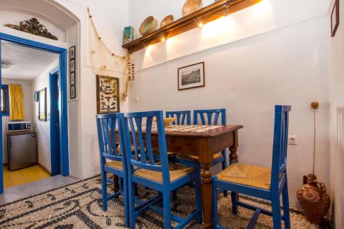 comedor azul con mesa de madera y sillas en Al 583 di Lindos en Líndos