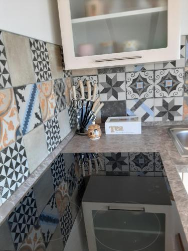 a kitchen with a counter with tiles on the wall at Red Rose Apartment in Portorož
