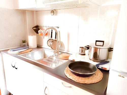 a kitchen with a sink and a frying pan on a counter at VILLA MARAVGIA APARTMENT B in Akti Salonikiou