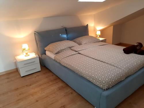 a bedroom with a blue bed with two lamps on a night stand at Red Rose Apartment in Portorož