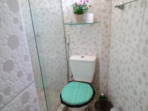 a bathroom with a toilet with a glass shower at Recanto dos Pássaros Olivença in Ilhéus