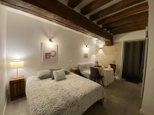 a bedroom with a bed and a table in it at La Ferme de Labbeville in Labbeville