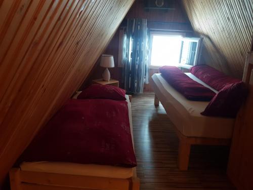 a attic room with two beds and a window at Enjoy the Silence Holiday Home in Vlasic