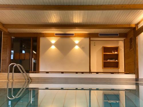 a swimming pool with lights on the wall at Haus Jäger Ferienwohnungen mit Indoor-Pool in Ruhpolding