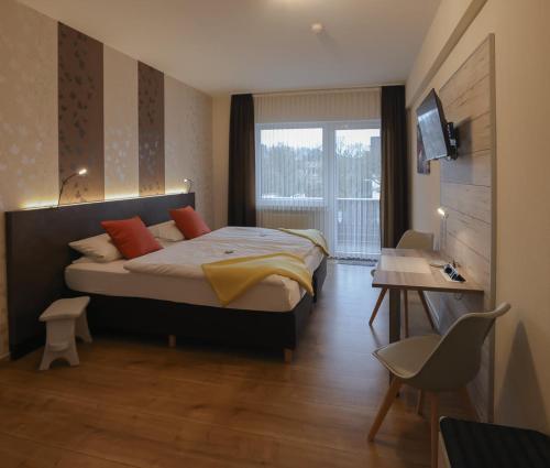 a bedroom with a large bed and a window at Gasthaus zur Quelle in Bad Marienberg