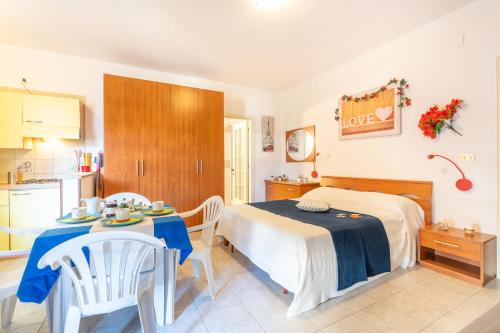 ein Schlafzimmer mit Bett und Tisch und eine Küche in der Unterkunft Green Marine L2 Silvi Vacanza in Silvi Marina