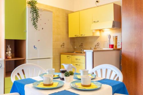 eine Küche mit Tisch und Stühlen und eine Küche mit gelben Schränken in der Unterkunft Green Marine L2 Silvi Vacanza in Silvi Marina