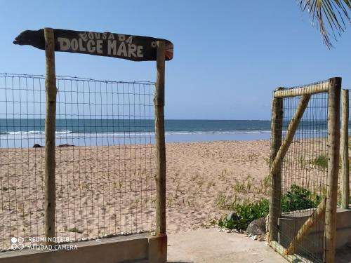 einen Zaun an einem Strand mit dem Ozean im Hintergrund in der Unterkunft Pousada Dolce Mare in Cacha Pregos