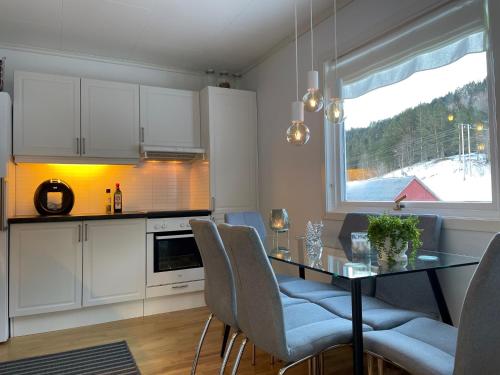 een keuken met een tafel en stoelen en een raam bij Tunold Gård - Kårhus in Mindresunde