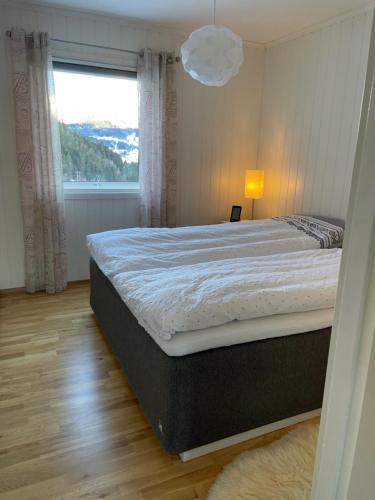 a bedroom with a large bed and a window at Tunold Gård - Kårhus in Mindresunde