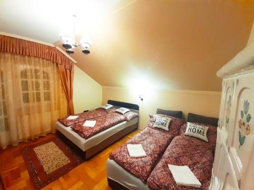 a bedroom with two beds and a window at Mátra Wellness Vendégház in Parádsasvár