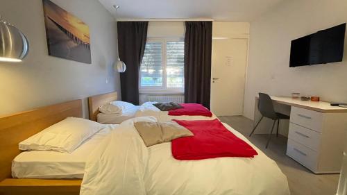 1 dormitorio con 2 camas y escritorio con ordenador en Relais de l'Aérodrome, en Prangins