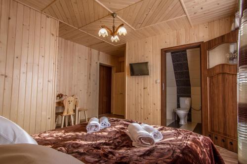 a bedroom with a bed with towels on it at Willa Floryn in Bukowina Tatrzańska