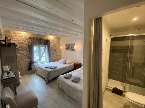 a hotel room with two beds and a bathroom at La Ferme de Labbeville in Labbeville