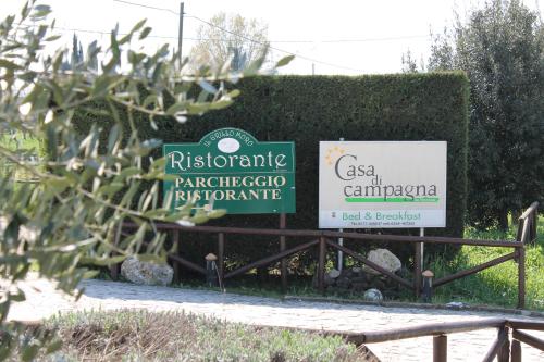 two signs on a fence in front of a hedge at Casa Di Campagna In Toscana in Sovicille
