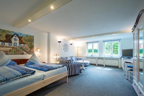 a bedroom with a bed and a desk in it at Inselhotel Arfsten in Wyk auf Föhr