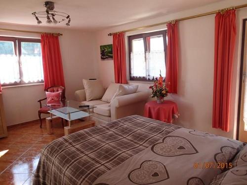 a bedroom with a bed and a living room at Haus Neuhäusl inkl. Chiemgaukarte in Ruhpolding