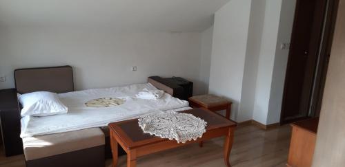a small room with a bed and a table at Guest House Raffe in Dobrinishte