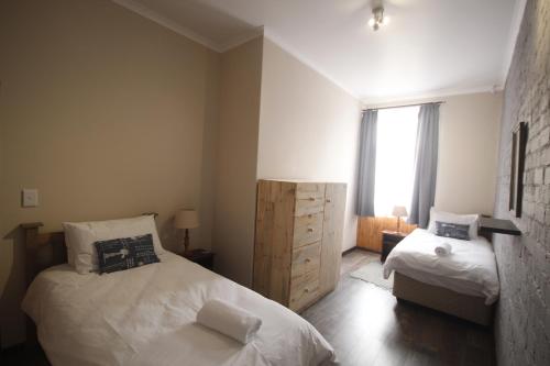 a small bedroom with two beds and a window at Eazy Sleep Accommodation in Swakopmund