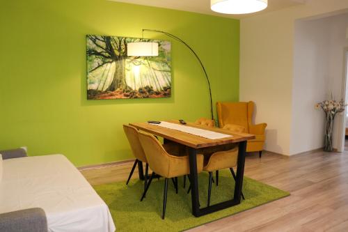 ラシュノフにあるApartamente Bucegiの緑の壁のダイニングルーム(テーブル、椅子付)