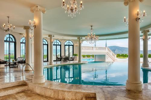 an indoor pool in a building with chandeliers at Mövenpick Resort Khao Yai in Ban Wang Sai
