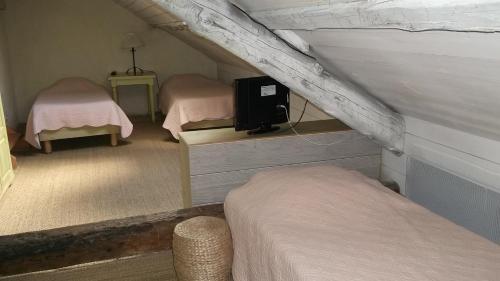 a room with two beds and a tv on the wall at La Pastorale in La Bâtie-Neuve