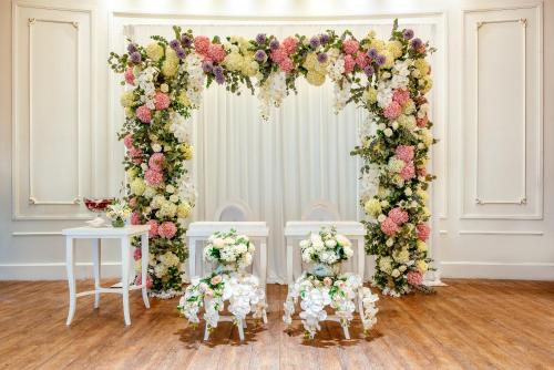 a floral arch with flowers and tables and chairs at Mövenpick Resort Khao Yai in Ban Wang Sai