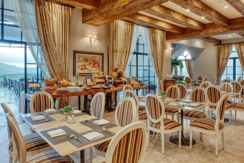 a dining room with tables and chairs and large windows at Mövenpick Resort Khao Yai in Ban Wang Sai