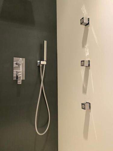 a shower with a white hose on a wall at le gite du CASTELBOSC in Hagedet
