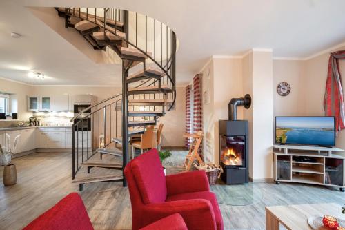 un salon avec un escalier en colimaçon et une cheminée dans l'établissement Bauernhof Lafrenz, à Fehmarn