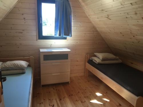 une petite chambre avec deux lits et une fenêtre dans l'établissement Domki Letniskowe Kaja, à Rewal