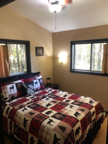 Un pat sau paturi într-o cameră la Mountain-top Cabin Get-away with Hot tub and a View