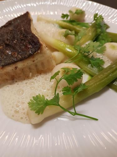 un plato de comida con carne y verduras. en Hôtel Les Prateaux, en Noirmoutier-en-l'Île