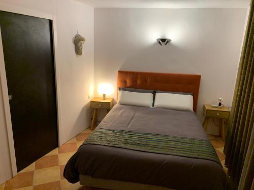 ein Schlafzimmer mit einem Bett mit zwei Lampen und einer Tür in der Unterkunft PILA & BED Montpellier Centre Corum Comédie - Chambre calme climatisée - Quiet air-conditioned room in Montpellier