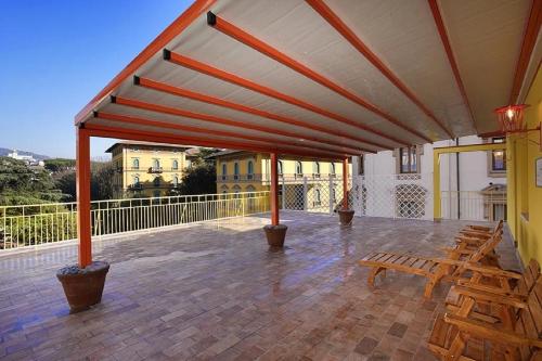 a patio with benches and tables on a balcony at Attico Incerpi, terrazza sui tetti di Montecatini Terme in Montecatini Terme