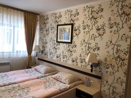 1 dormitorio con cama y papel pintado con motivos florales en Apartment 507 The Castle 1 en Pamporovo