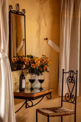 a table with a vase of flowers and a mirror at Hotel Valle Místico in Tepoztlán