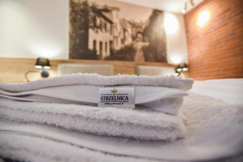 une pile de serviettes assises au-dessus d'un lit dans l'établissement Strzelnica Hotel i Restauracja, à Starogard Gdański