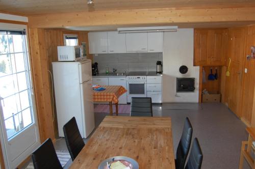 a kitchen with a wooden table and a refrigerator at Casa Gion Giusep in Sedrun