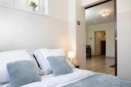 sypialnia z łóżkiem z białą pościelą i niebieskimi poduszkami w obiekcie Luxus Apartament Wzgorze w mieście Gdynia