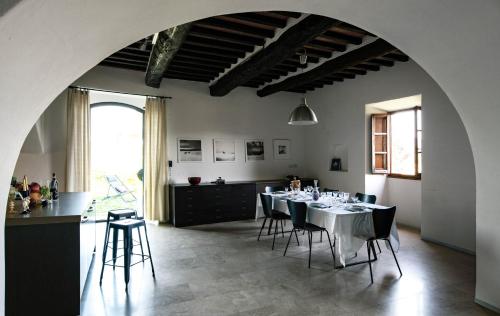 a room with a table with chairs and a kitchen at canonica 43 in Colle di Val d'Elsa