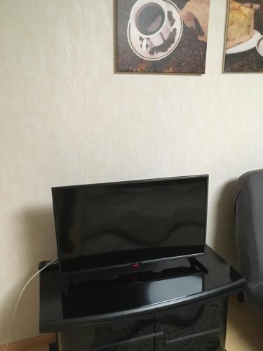 uma televisão de ecrã plano em cima de uma mesa preta em Apartament mit Balkon em Lahr